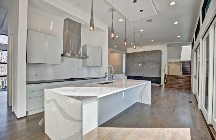 Clean Open Kitchen with Marble Kitchen Island and a PLFW 750 Wall Range Hood