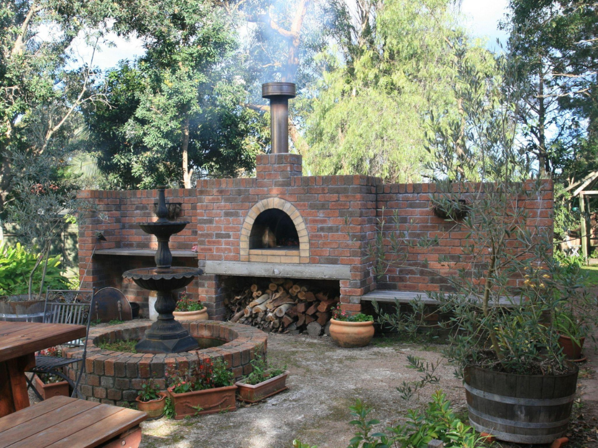 Large brick pizza oven with wood underneath