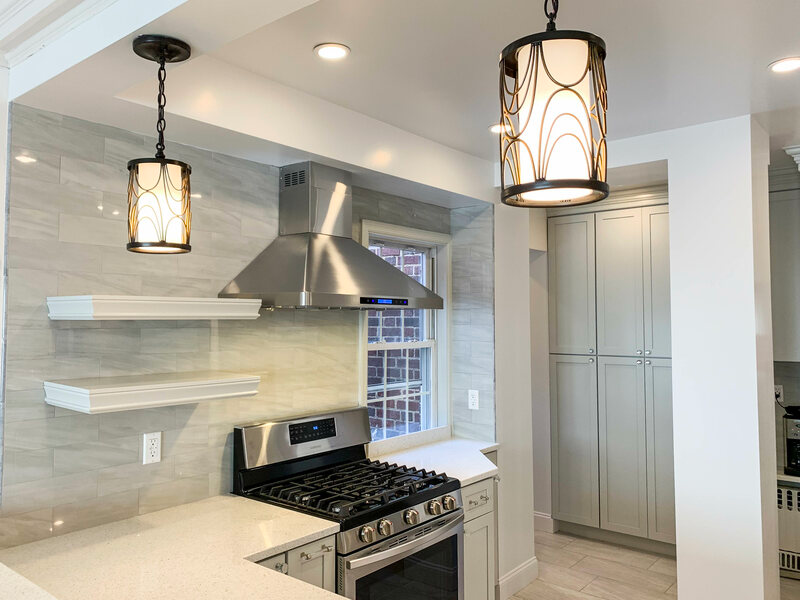 Vent hood over gas stove with fancy hanging light fixtures