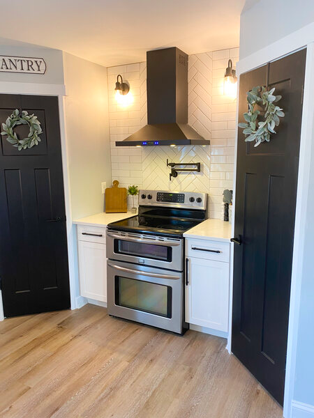 Black vent hood over electric stove in small kitchen