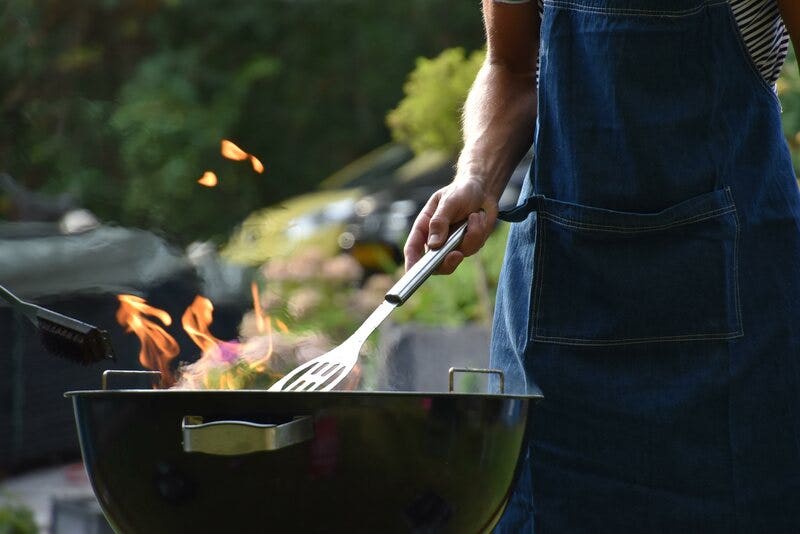 Man Cooking at a Charcoal Grill