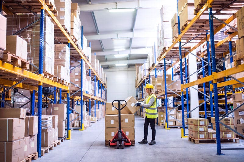 Woman Loading Boxes in Warehouse