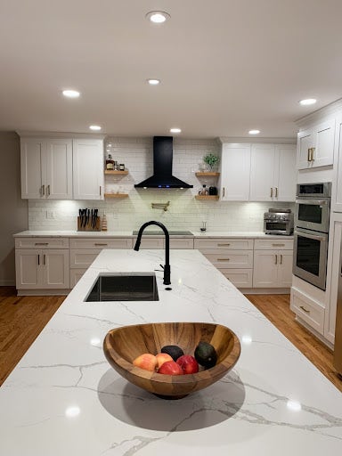 Black matte wall range hood with white cabinets