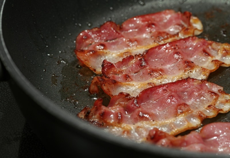 cooking bacon in a pan