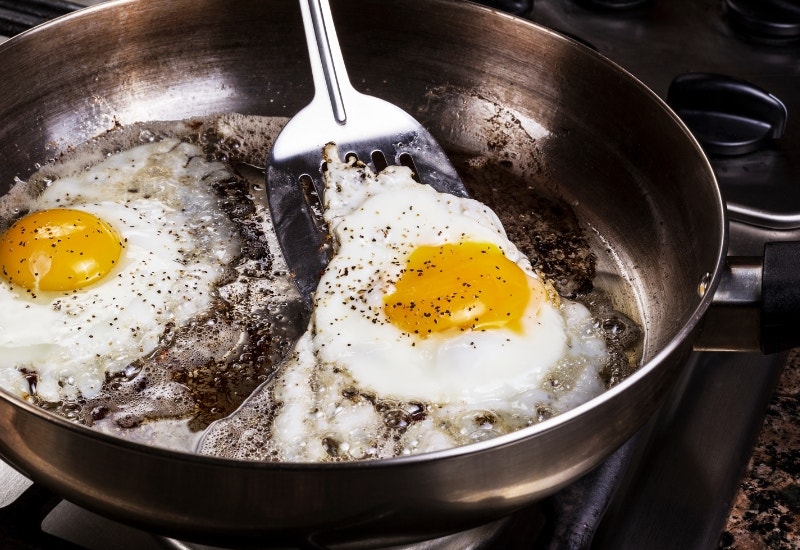 eggs cooking in bacon grease in a pan