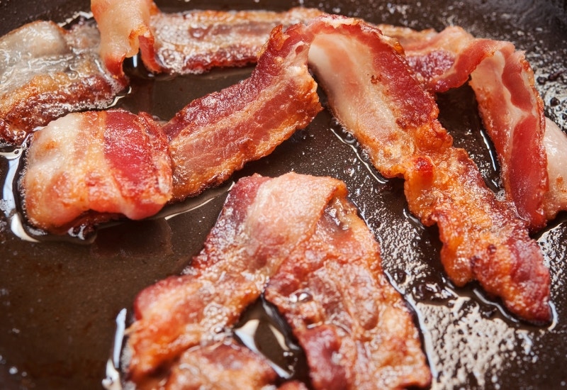 sizzling bacon in a pan