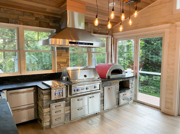 outdoor kitchen idea number 2 - covered space with lights
stainless steel appliances with a big range hood pizza oven
