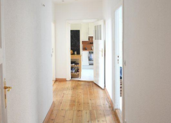 Wooden hallway with white walls