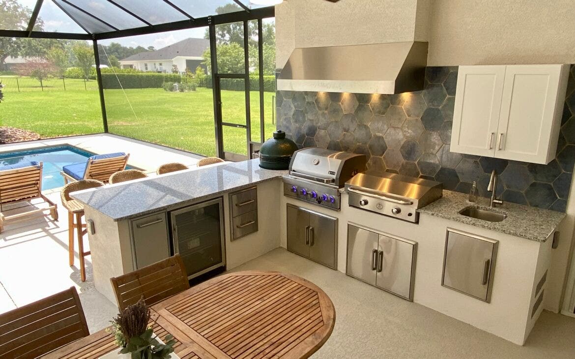 outdoor grilling station with a pool and stainless steel appliances  - Proline Range Hoods - prolinerangehoods.com