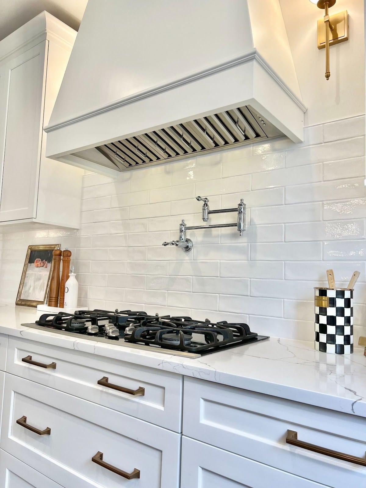 Close-up of a white kitchen countertop with a stainless steel stovetop oven. - Proline Range Hoods - prolinerangehoods.com 