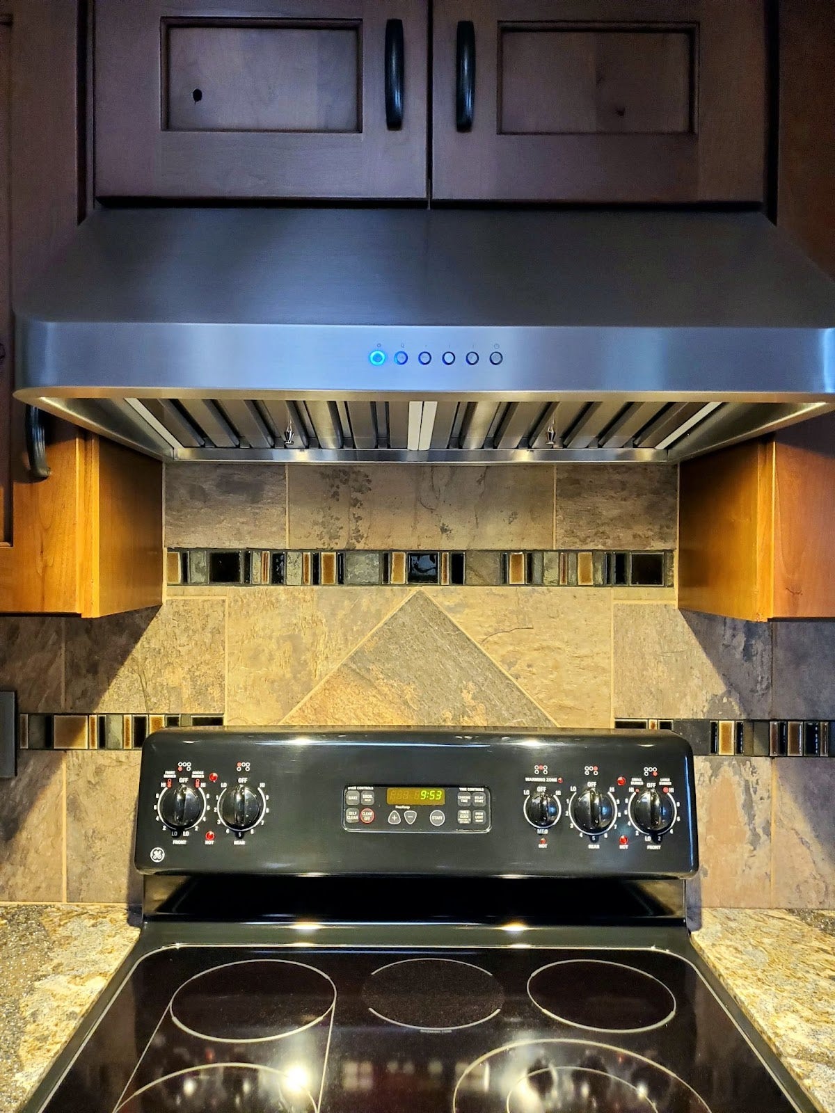 Kitchen with mosaic tile backsplash, Proline range hood, and stainless steel appliances. - Proline Range Hoods - prolinerangehoods.com 