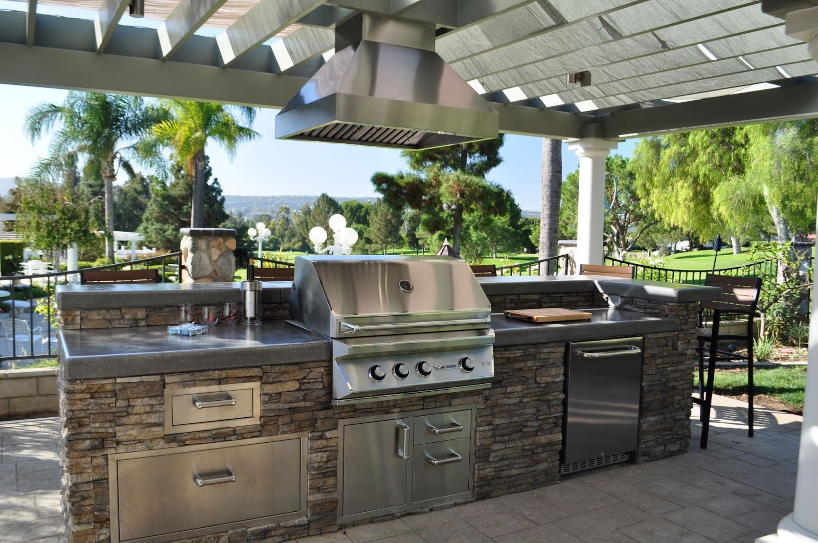 Sunny Escape Kitchen: This open-air kitchen is perfect for easy living. The Proline PLJI 103.42 hood vents smoke while you cook and dine under the sunshine. Stone accents and stainless steel appliances add a touch of style to this laid-back entertaining space. - Proline Range Hoods - prolinerangehoods.com 