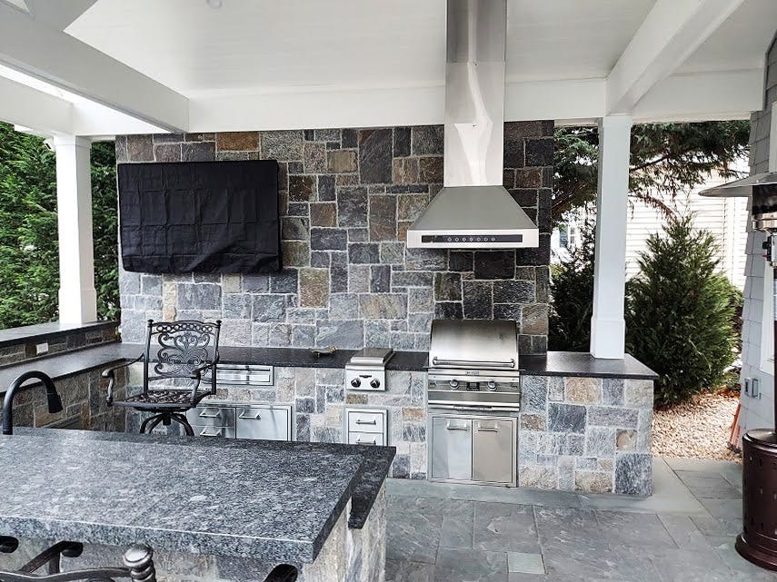 Stone & Stainless Steel Grilling Nook: Proline PLJI 102 hood vents smoke in this stylish outdoor kitchen. Stone and stainless steel create a sleek look. Perfect for entertaining with a modern entertainment system nearby. - Proline Range Hoods - prolinerangehoods.com 