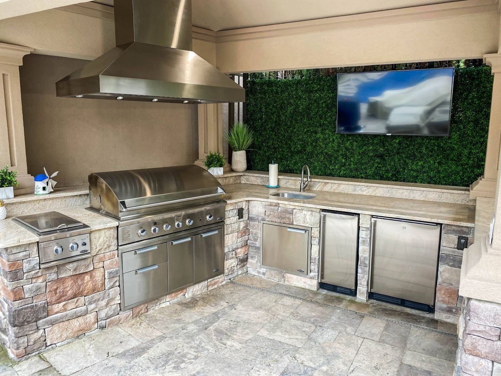 Smokeless Outdoor Kitchen: Proline ProVI hood keeps the air clear for entertaining in this stylish outdoor kitchen. Stone counters and a verdant view create a sophisticated space for grilling and socializing. - Proline Range Hoods - prolinerangehoods.com 