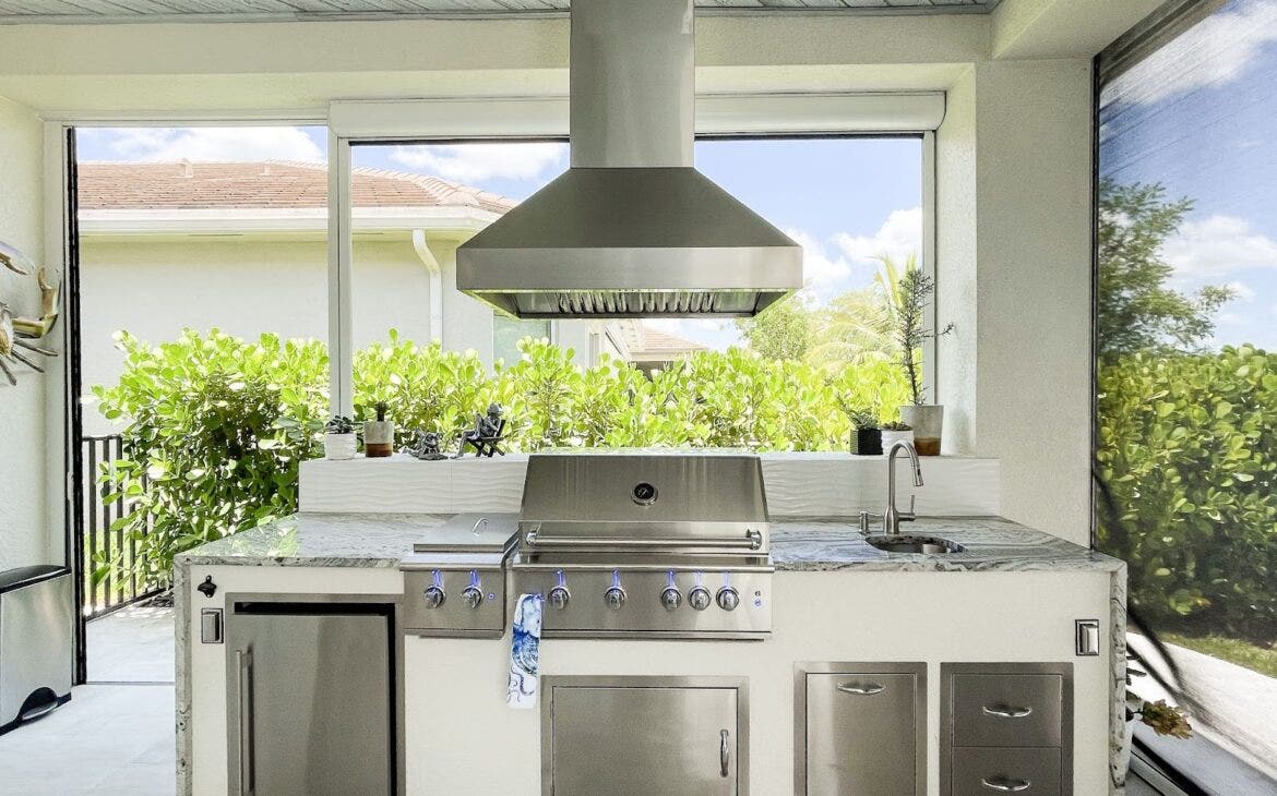 Tropical Outdoor Kitchen: Proline PLJI 103 hood keeps the air clear in this sunny outdoor kitchen. Stainless steel grill contrasts with the leafy surroundings. Perfect for grilling and relaxing. - Proline Range Hoods - prolinerangehoods.com 