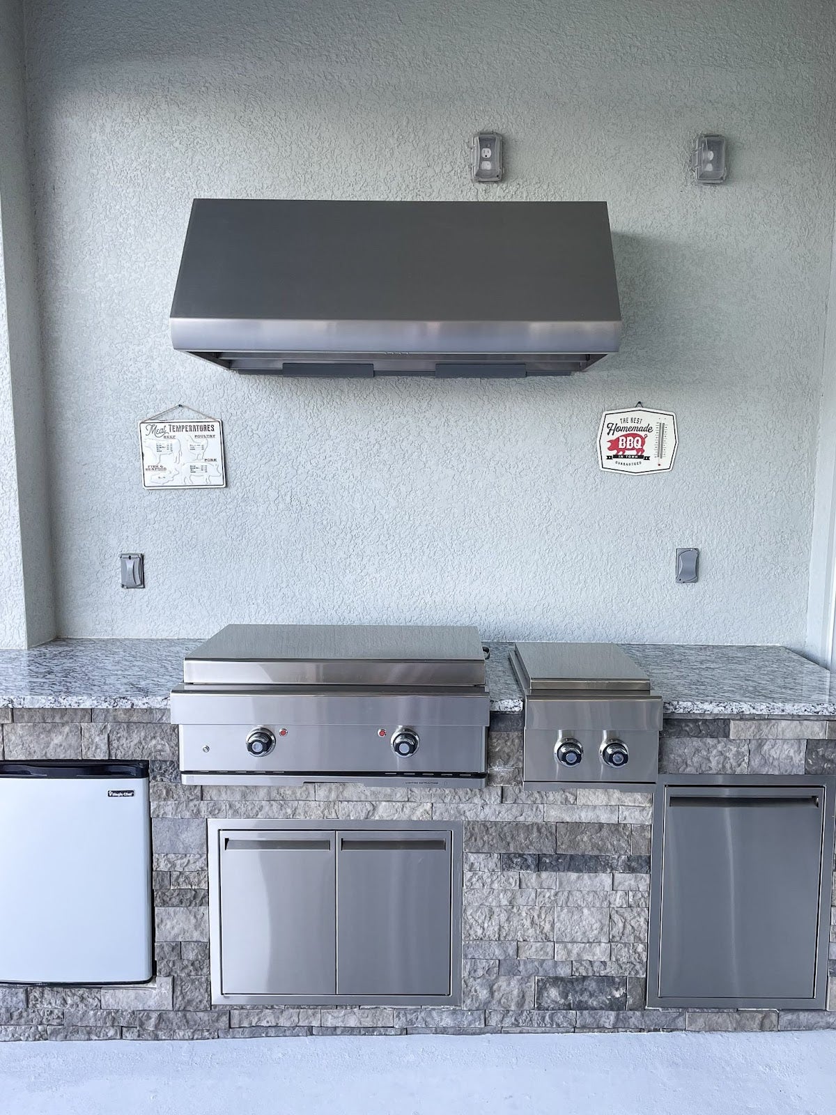 Sleek outdoor kitchen featuring a Proline range hood, granite countertops, and built-in stainless steel appliances for a modern cooking experience - prolinerangehoods.com