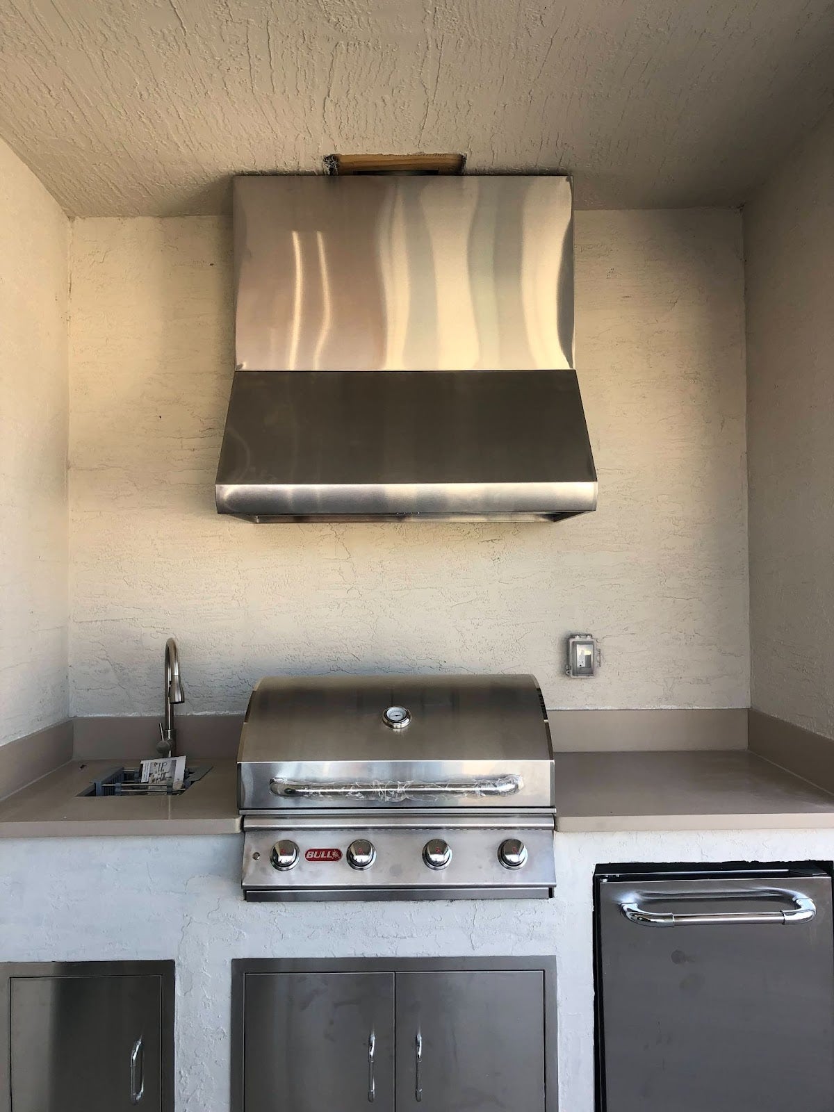 Compact and modern outdoor grill area featuring a Proline range hood, with clean lines and stainless steel cabinetry for a sleek cooking experience - prolinerangehoods.com.