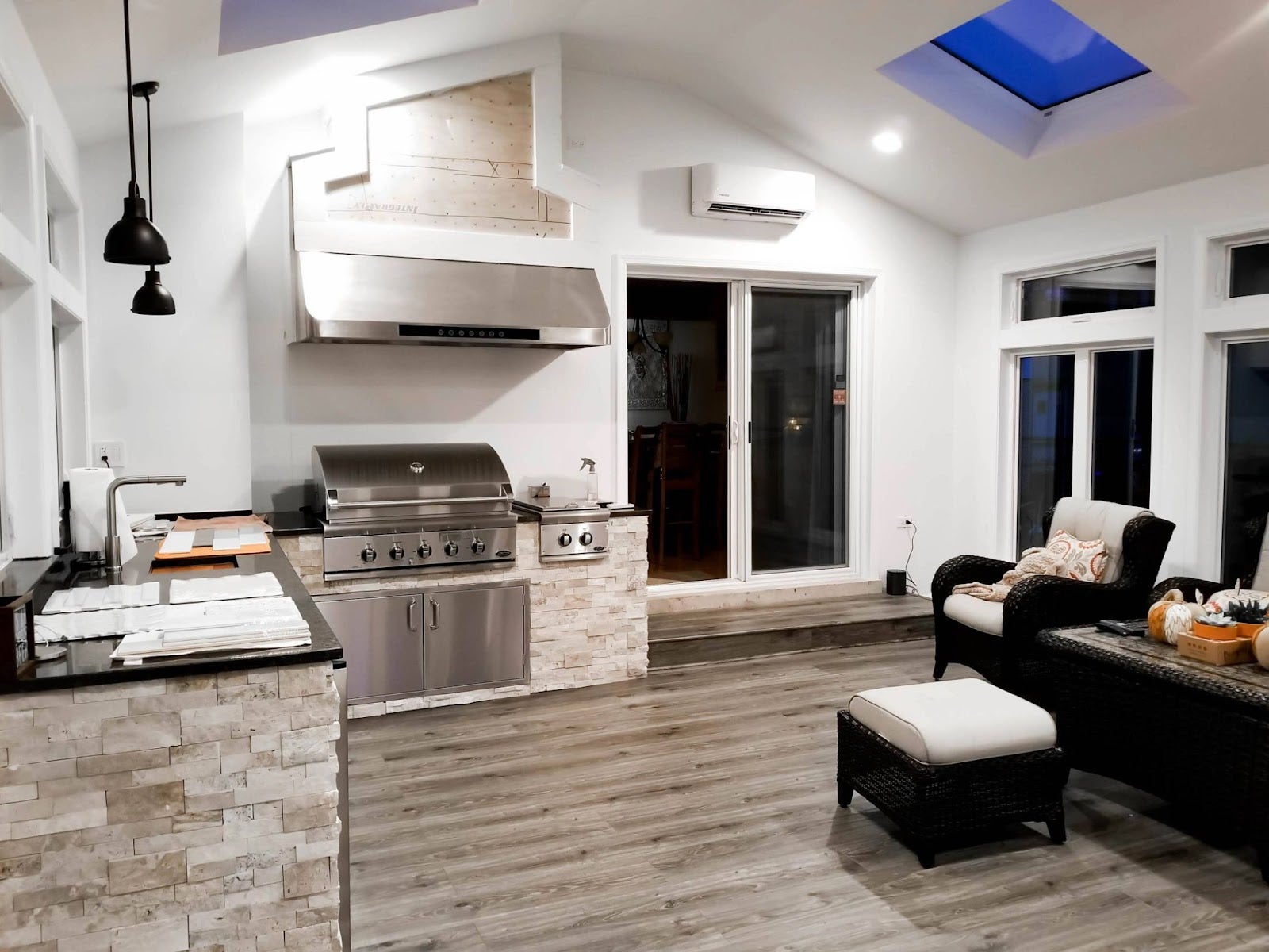 Spacious indoor patio with a Proline range hood over a grill, modern furniture, and skylights for natural lighting - prolinerangehoods.com