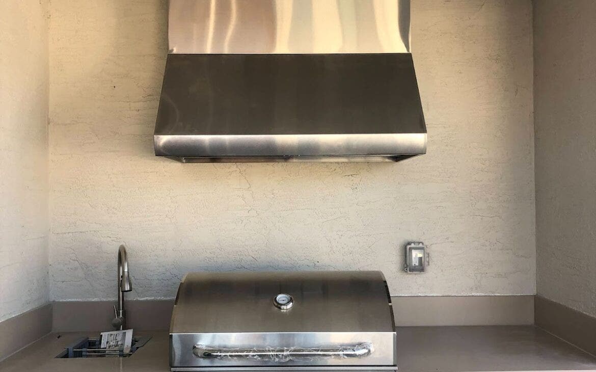 Compact and modern outdoor grill area featuring a Proline range hood, with clean lines and stainless steel cabinetry for a sleek cooking experience - prolinerangehoods.com.