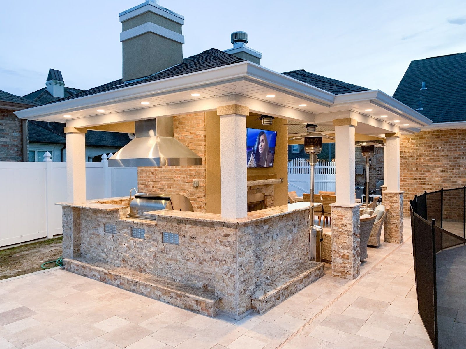 Proline range hood in a luxurious outdoor kitchen pavilion with evening lighting - prolinerangehoods.com
