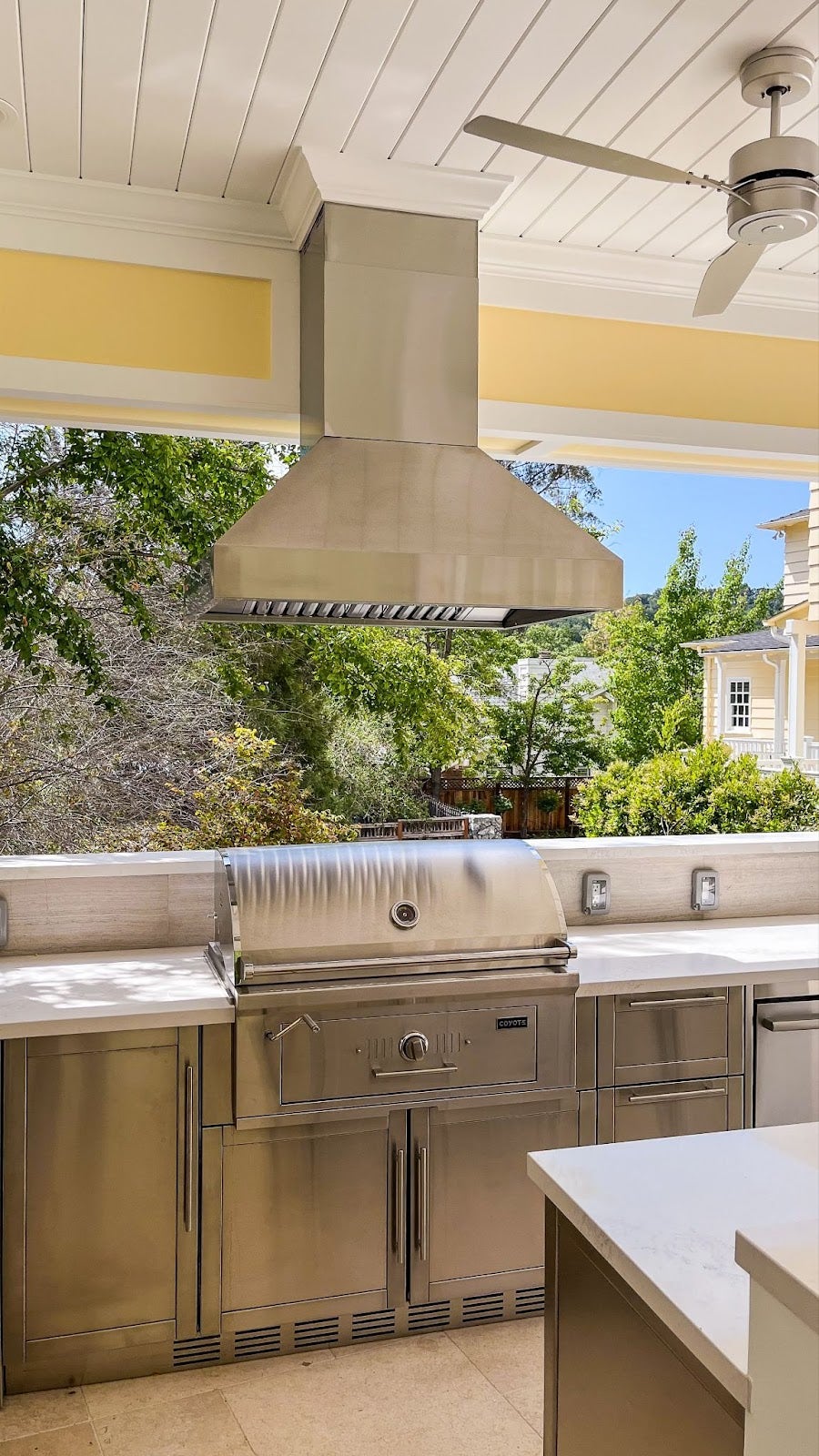 Modern Proline range hood in a beautifully designed outdoor kitchen with garden views - prolinerangehoods.com